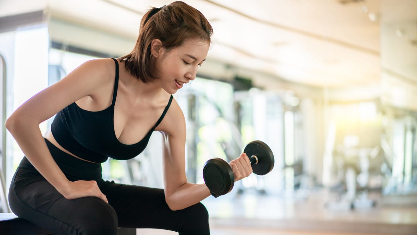 Femme qui fait un exercice de musculation avec une altère